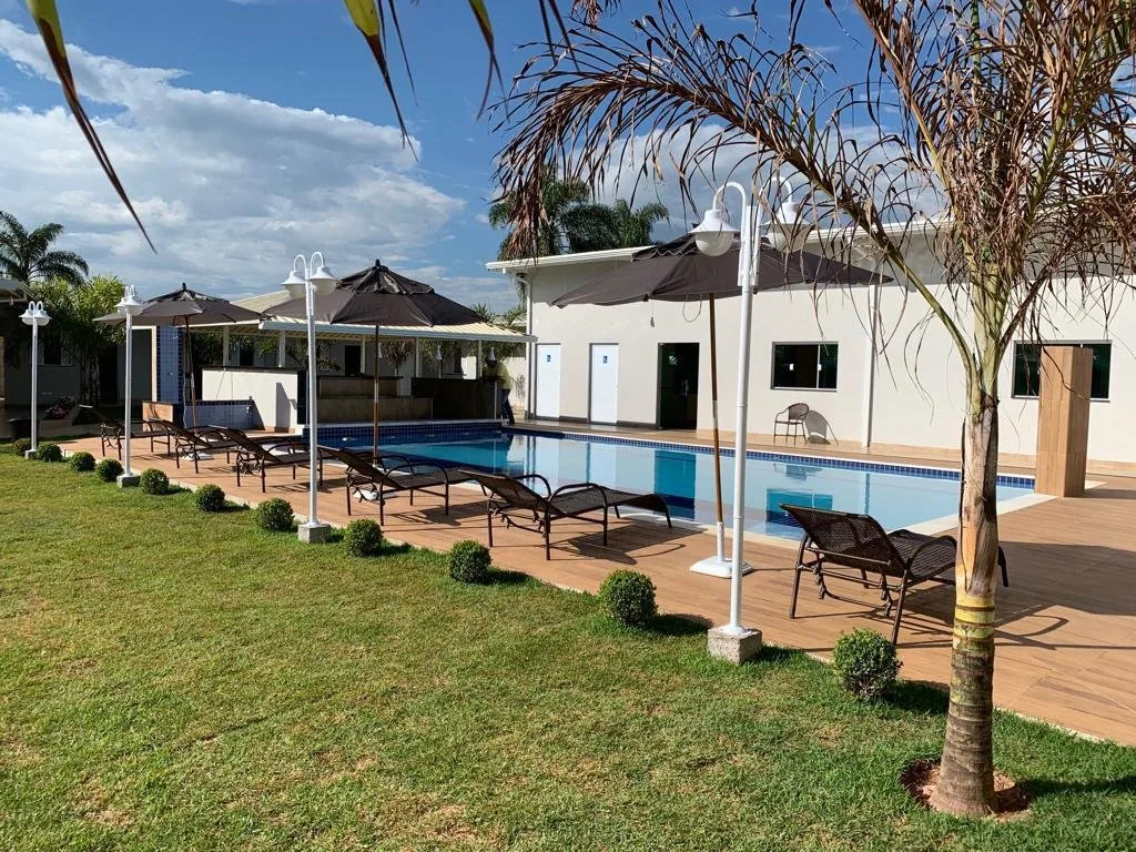 Piscina com deck, espreguiçadeiras e ombrelones