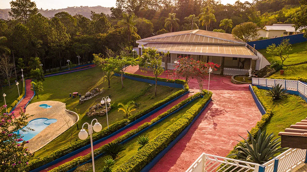Vista aérea do prédio principal com piscina e jardins ao lado