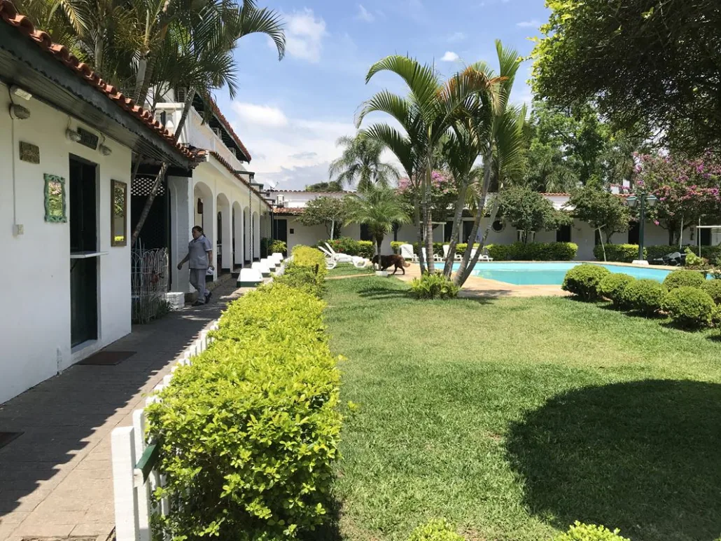 Varanda com portas verdes ao lado de gramado e piscina