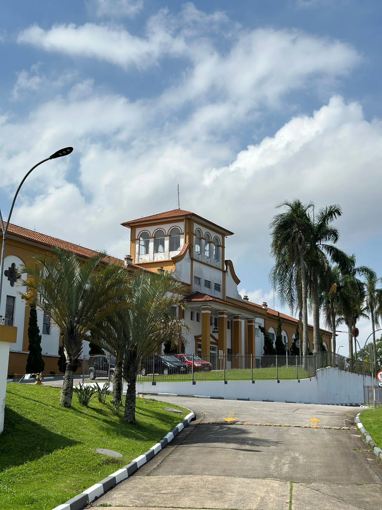 Prédio da Elibrè com torre, palmeiras e acesso de carros